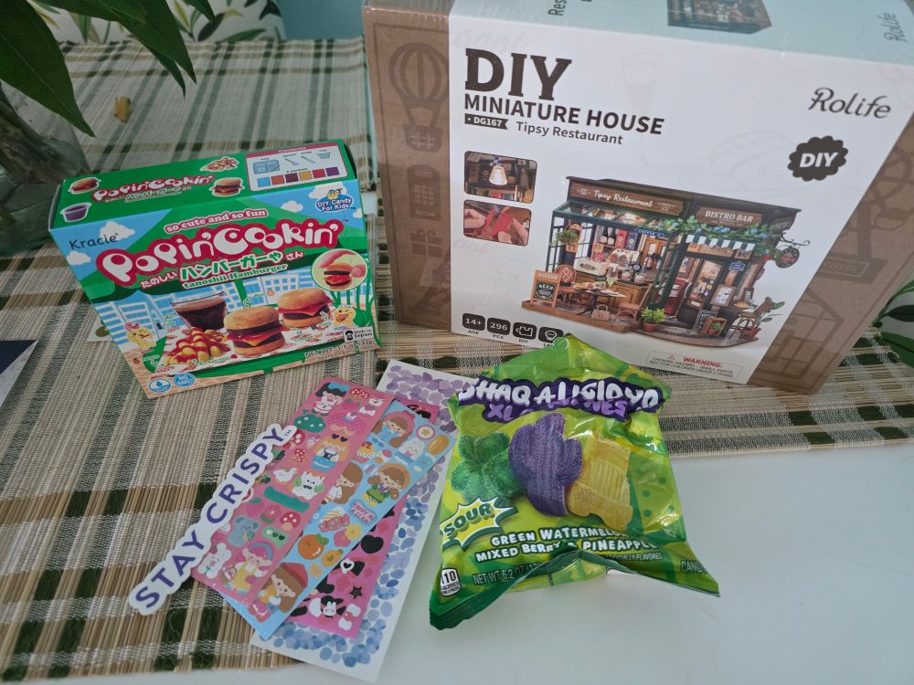 A gummy creation kit that makes gummy burgers, a DIY miniature house kit that's a restaurant, gummy candy, and stickers