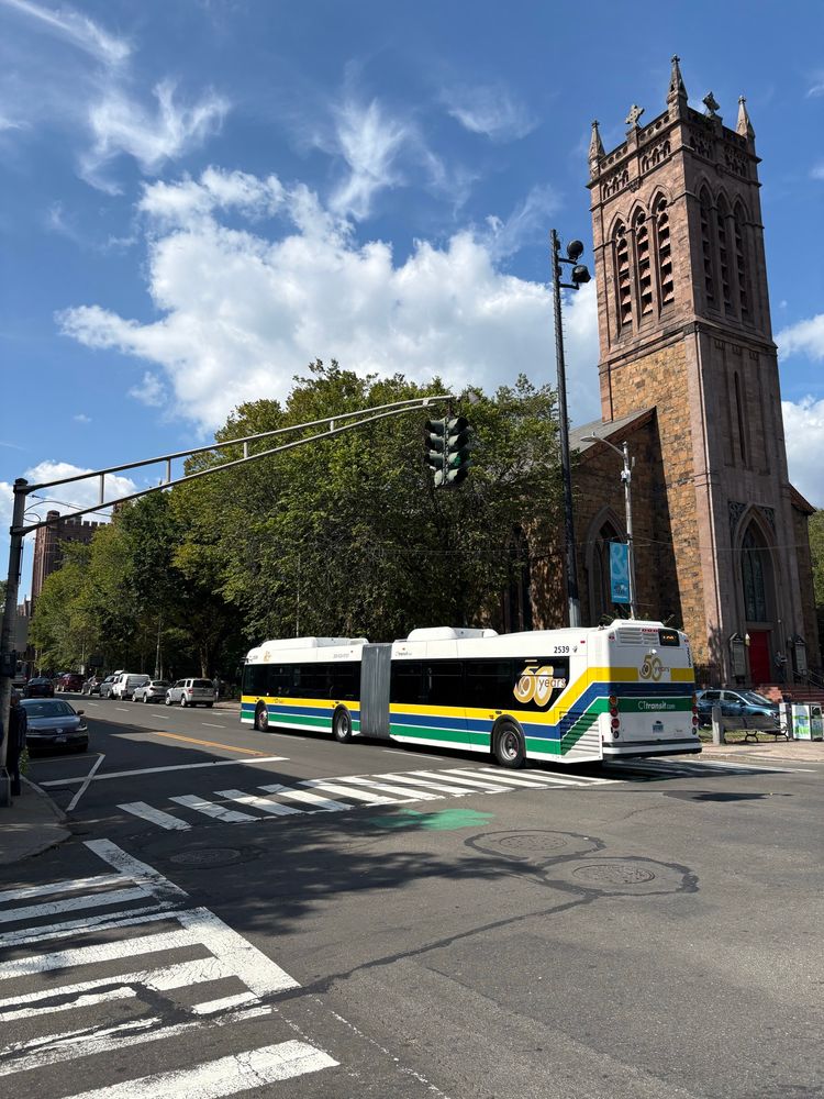 A CTtransit New Flyer XD60 with yellow, blue, and green stripes 