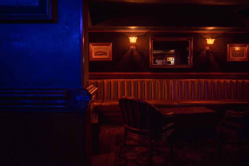 A dark but warmly lit lounge area in an empty bar. 
