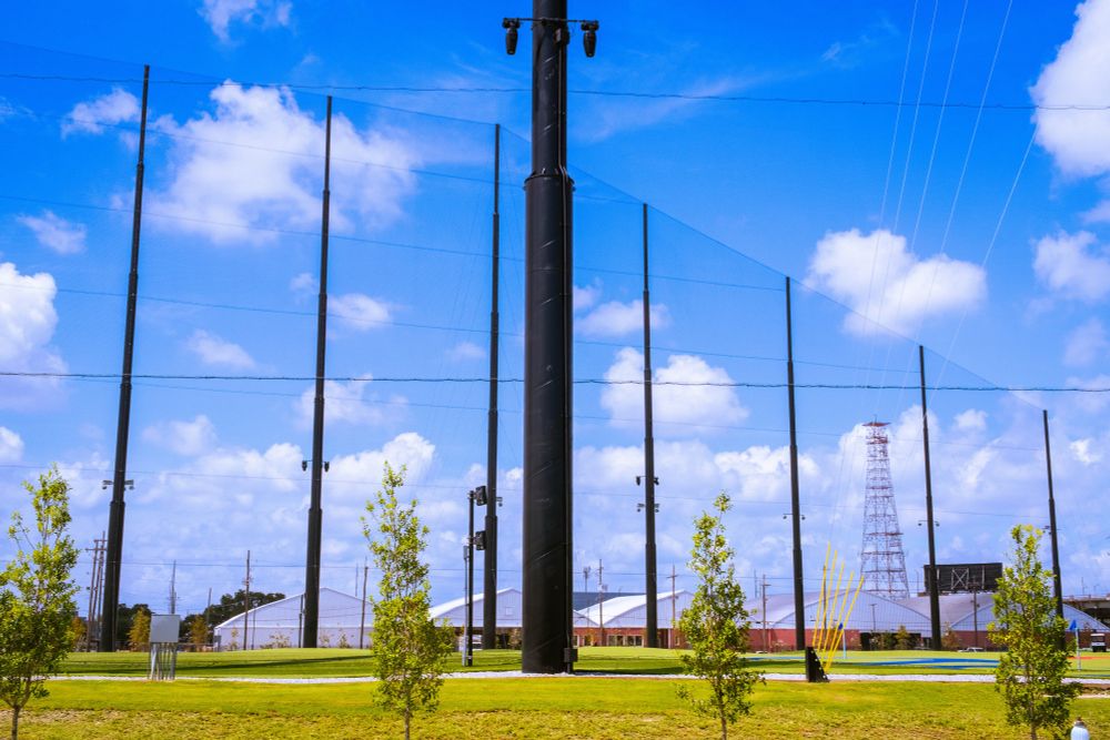Tall and imposing fencing around some sort of driving range/entertainment venue in New Orleans. 
