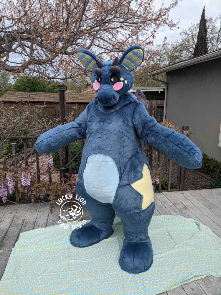A navy and baby blue plush dragon fursuit with star markings. 