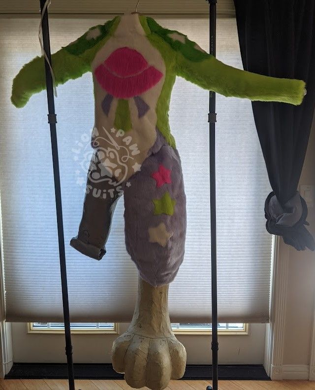 A photo of the work in progress stages of a fursuit body and feet with UFO and star markings.  