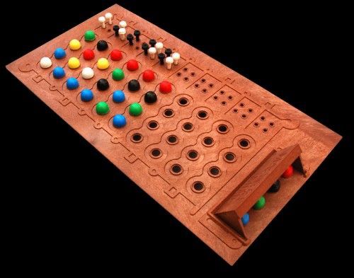 Photo of brown plastic game Mastermind. Shows hidden code of colored pegs. The player's view is trying different combinations of colors to try and match the secret. Black and white smaller peg give feedback on the guesses.