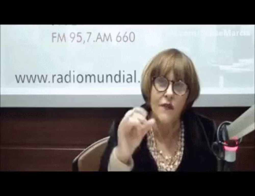 a woman wearing glasses is sitting in front of a microphone in front of a sign that says fm 95,7 am 660 .