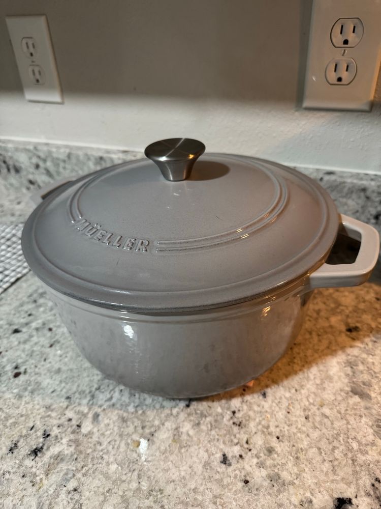 Grey Mueller brand Dutch oven sitting in a kitchen counter.
