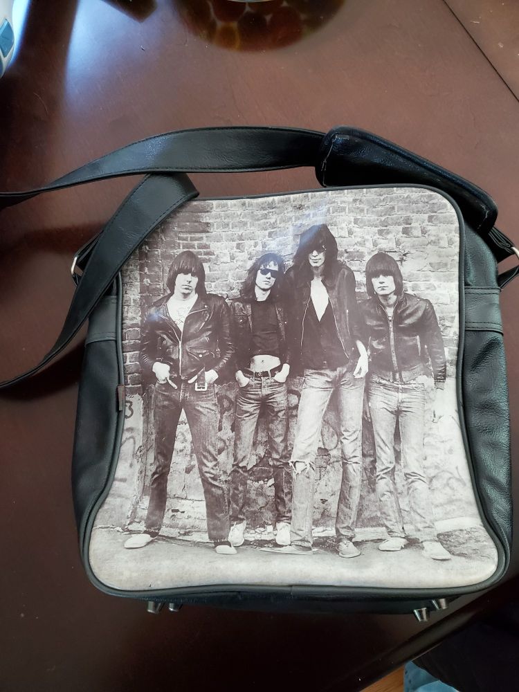 A book bag with a sepia toned photo of the iconic punk bad The Ramones on one side.