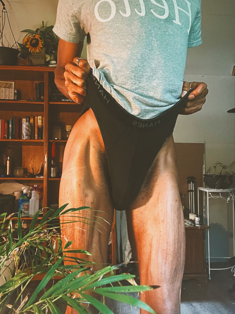 Darling is pulling their black underwear upwards on their hips, exposing their toned thighs