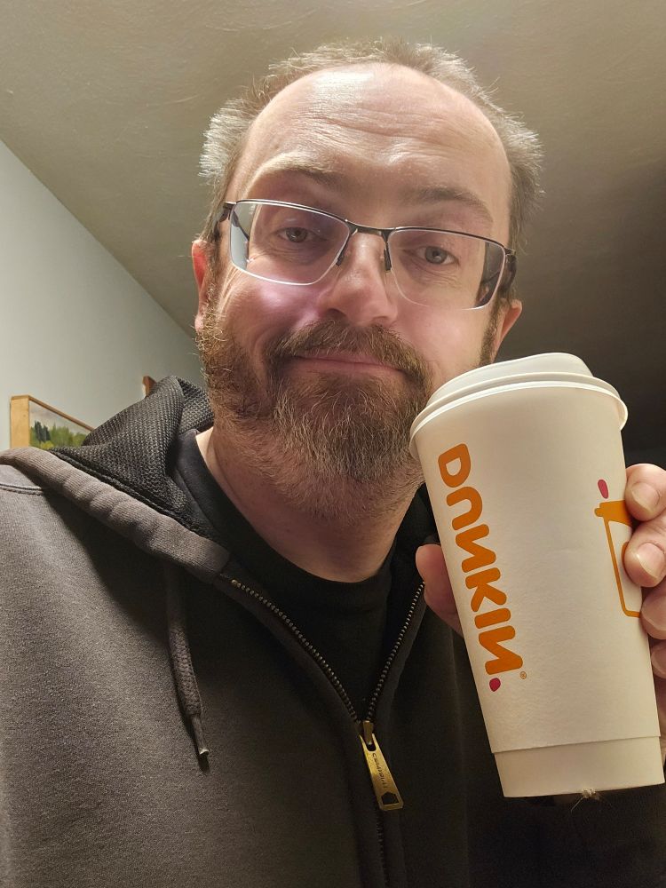 Jay with a Dunkin' cup.