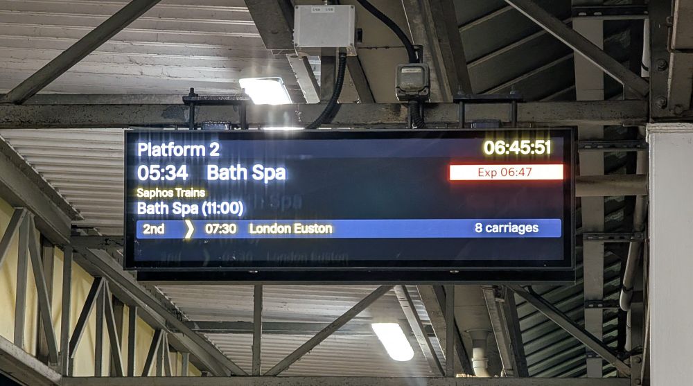 Departure board at Milton Keynes Central showing the 0534 Saphos Trains service to Bath Spa. The train is delayed by approximately 1h15.