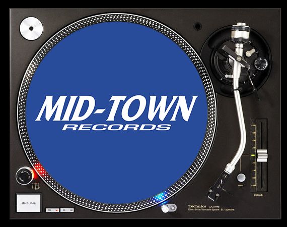 Turntable with a slipmat labeled 'Mid-Town Records'.