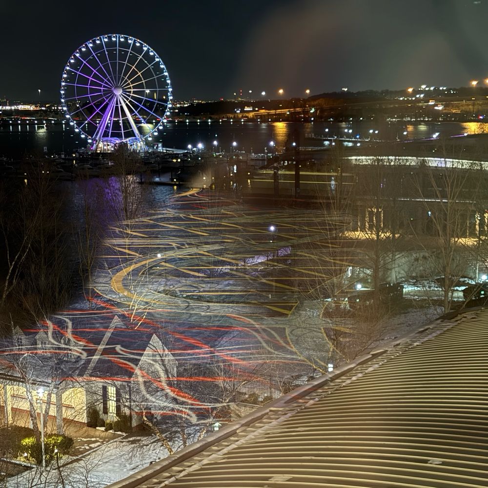 A Ferris wheel at night by the water 
