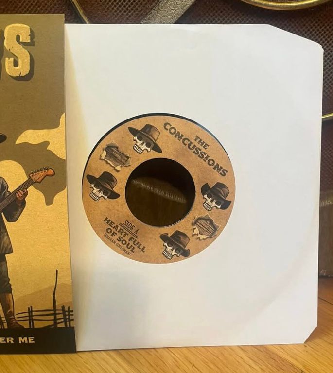 Record partially removed from sleeve showing the label of the new Concussions 45