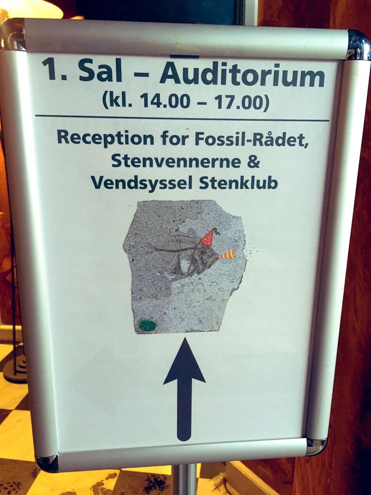Sign for reception with picture of fossil fish in a party hat