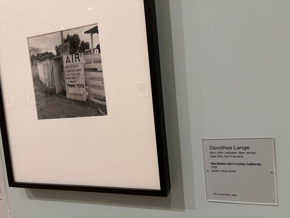 Dorothea Lange photo of a sign from 1940s that reads "This is your country don't let the big men take it away from you"