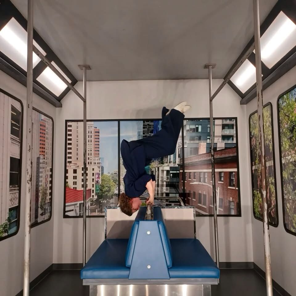 Me at the Museum of Illusions, doing a pull-up in the subway set, upside down.