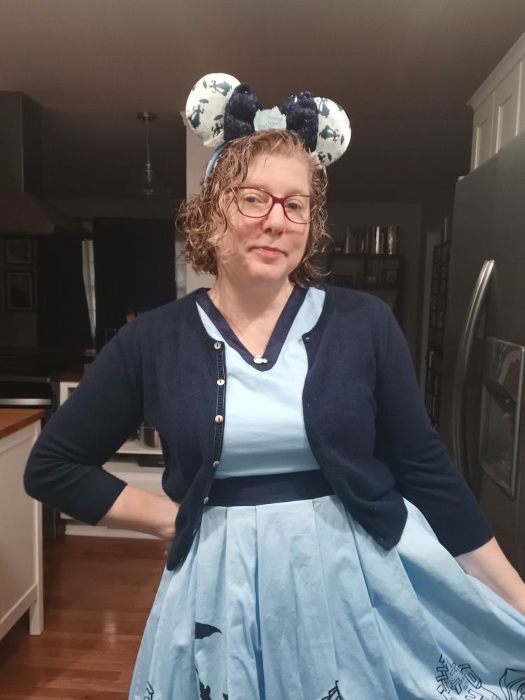 Me in a 50s style light blue & navy dress that has Mary Poppins silhouettes on the skirt, with matching cardigan and ears.