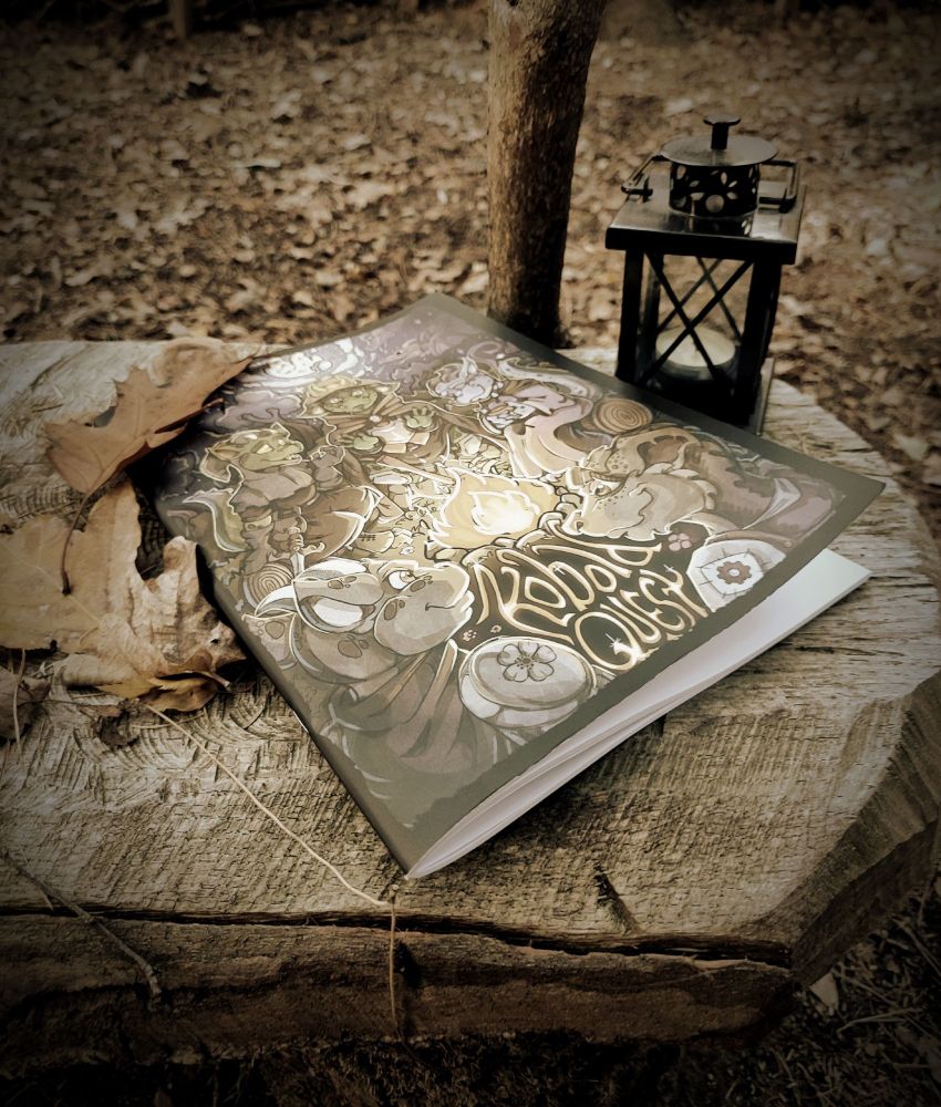 a sepia photo with the book "kobold quest" on a wooden bench. lantern and walking stick behind. leafy floor and some withered leaves next to the book