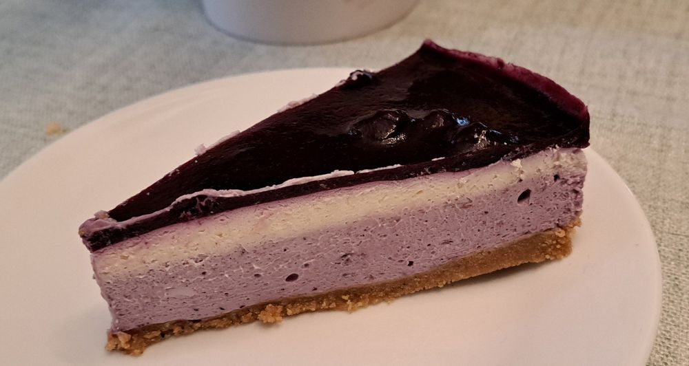 Three layered blueberry cheesecake on an oatmeal cookie crumb base.