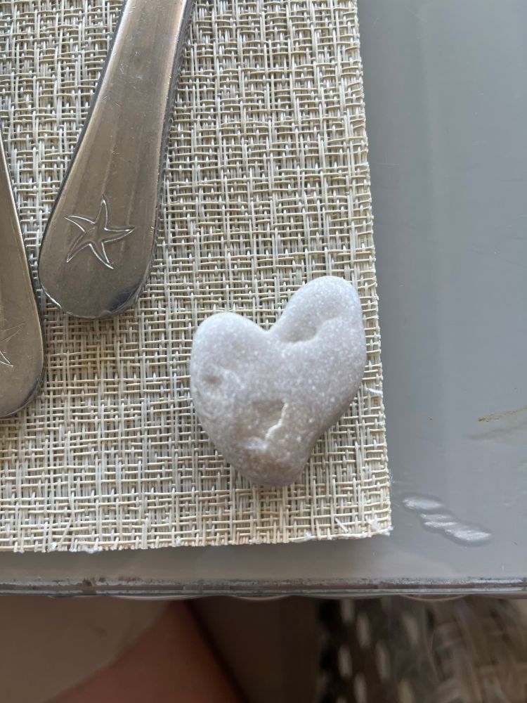 Heart shaped stone on a placemat. 