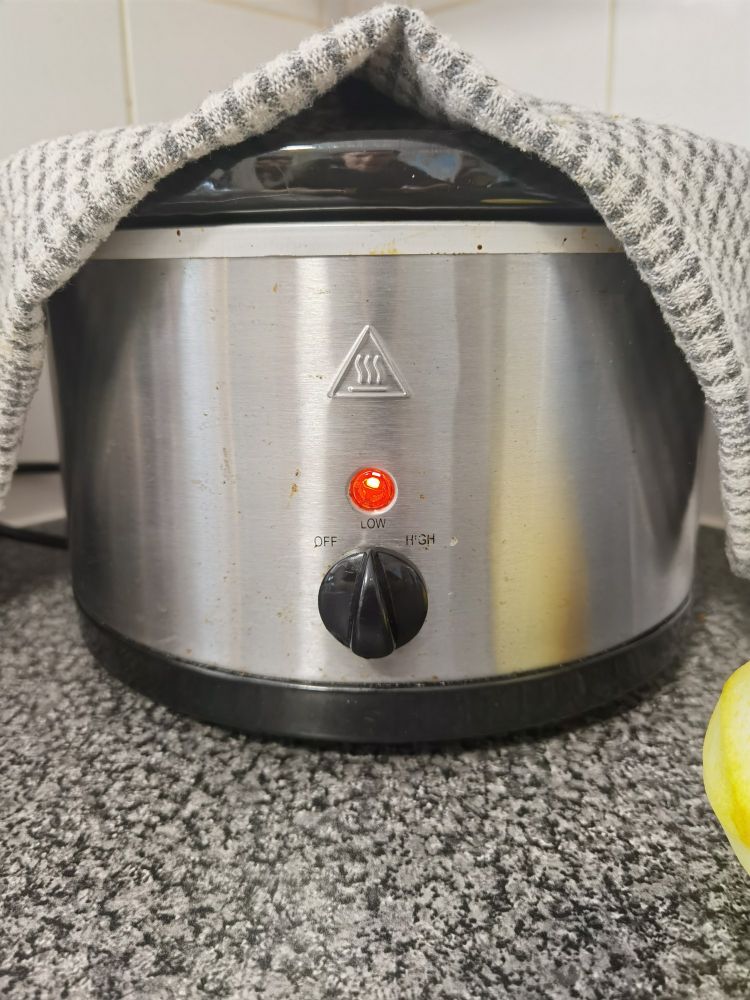 Slow cooker with tea towel covering the lid