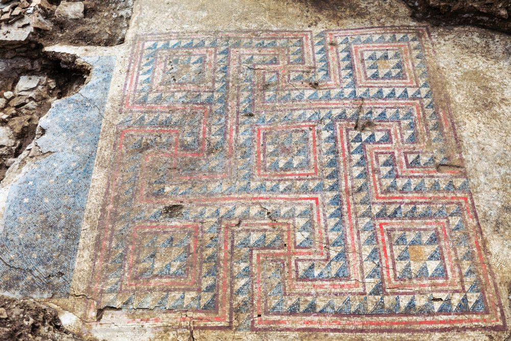Photo of the mosaic showing geometric patterns in white, black l, yellow, and red.