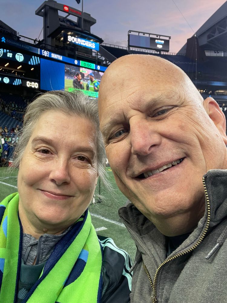 A woman and man Seattle sounders fans taking a selfie pitchside before the rivalry game with Portland Timbers  
