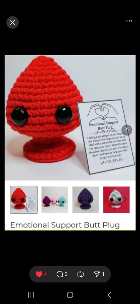 A crochet butt plug with sign reading Emotional Support Butt Plug.