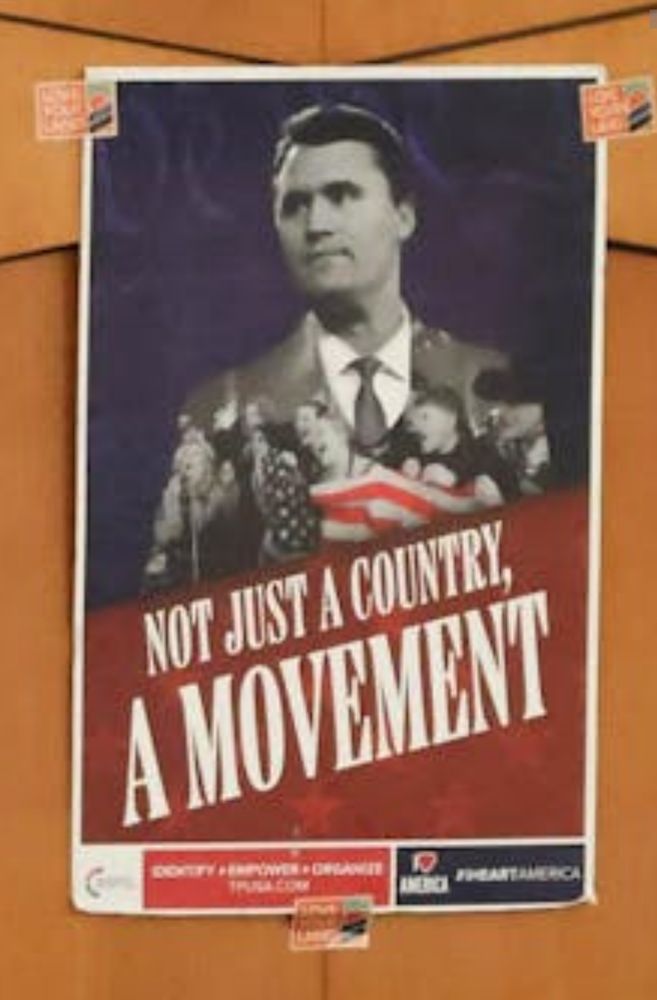 Turning Point USA poster displayed during event at the University of Florida, October 22, 2025. Poster features a black and white portrait of Chucky Kirk at a lectern. The posters title is "Not just a country, a movement." the poster resembles fascist propaganda posters propaganda. 