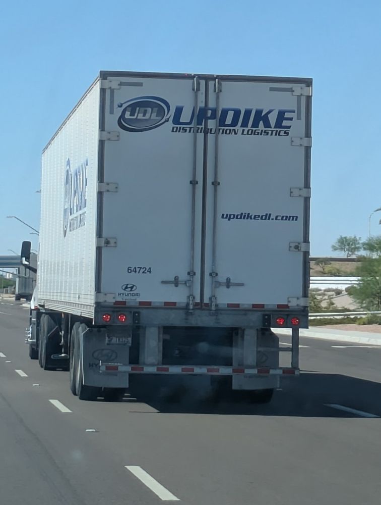 Picture of the back of a white 18 wheeler truck that says "UPDIKE" at the top of the back of the truck.

This is funny because it's like that joke about up dog, where someone says something about it smelling like "up dog", prompting the joke victim to say "what's up dog". Here, the joke is that the joke victims would say "what's up dyke" to me