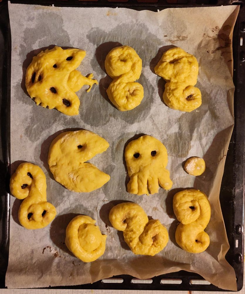 Saffron buns, one shaped like pacman and one like a ghost.