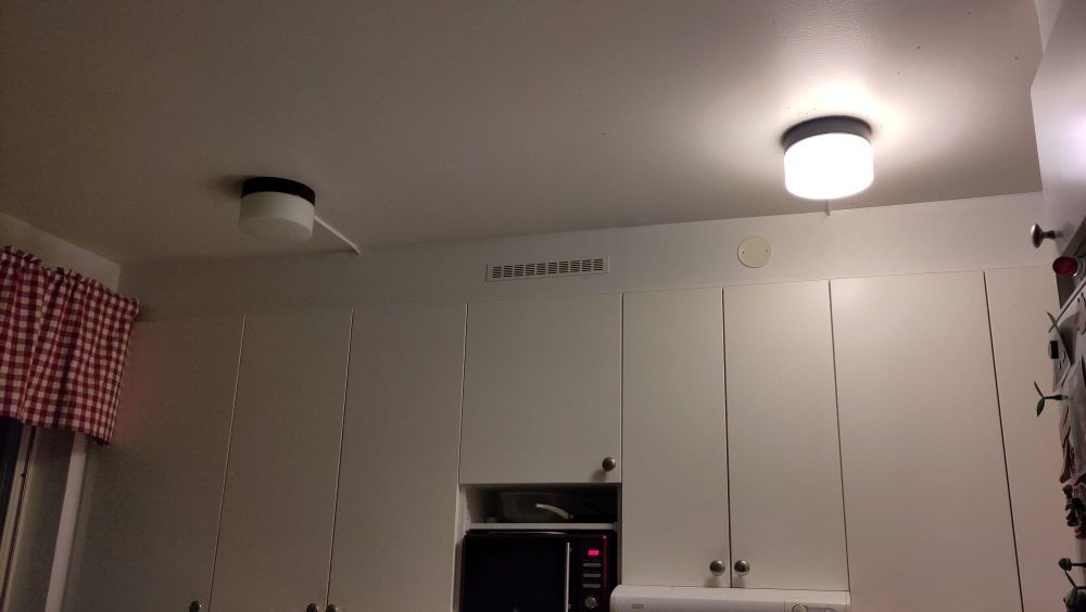 A ceiling with two lamps, one broken
