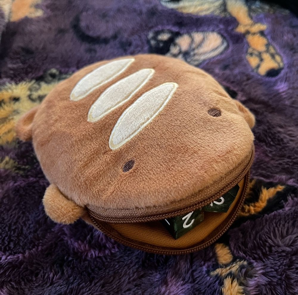 Breb the toad pouch with the pouch open with dice in his “mouth”