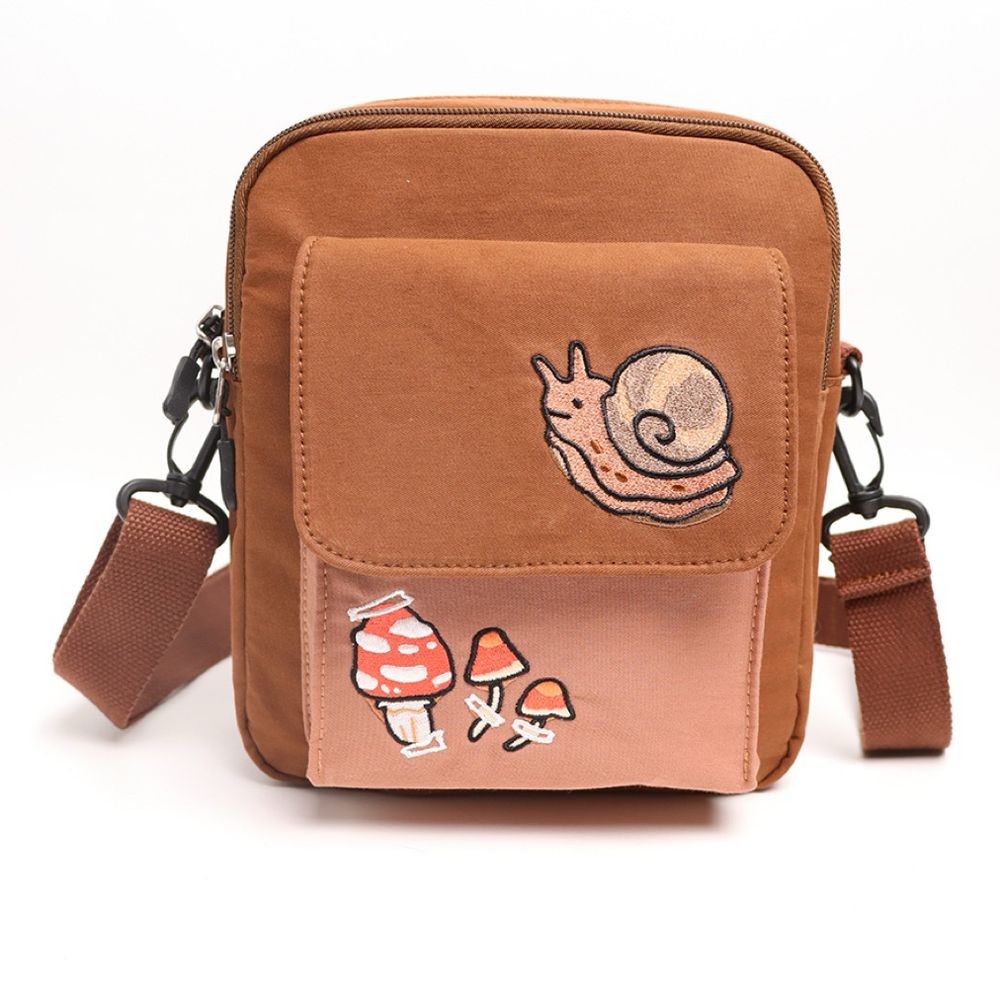 A brown crossbody bag with a snail on the top of the pocket and mushrooms on the bottom