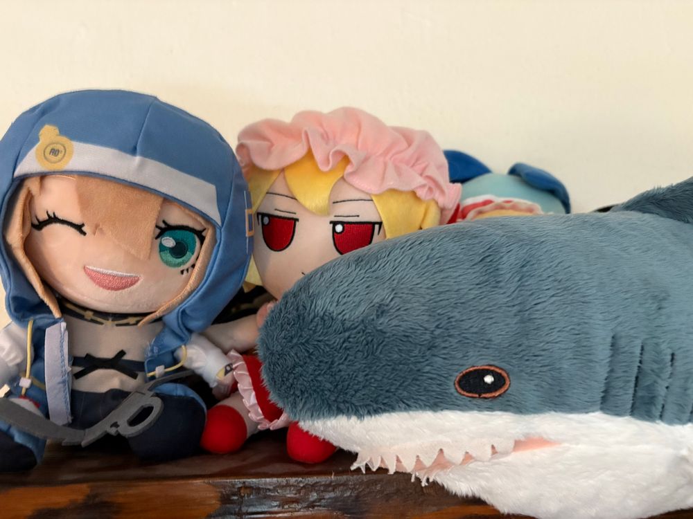 The tiny Blahaj, noted IKEA Shark, is perfectly sized for fumos.