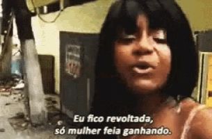 Meme da maravilhosa Catiuscia. Ela é uma mulher negra de cabelos lisos e escuros. Durante concurso de beleza, ela aproveita a presença da imprensa para desabafar: "Eu fico revoltada, só mulher feia ganhando".