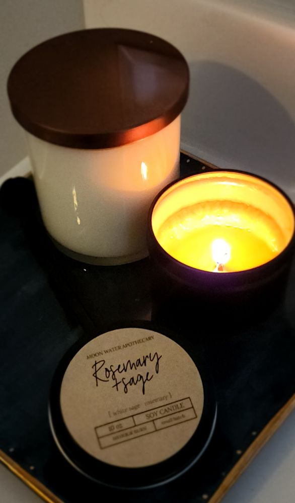 Ceramic plate with two candles. One is burning with a flame. 