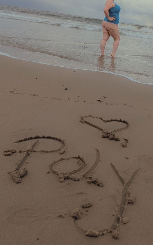 Polly is in the background wearing her turquoise tank and floral bra and panties, the ladder of which are basically hidden up her butt crack. In the foreground on the sand is written love, Poly. I missed you all!