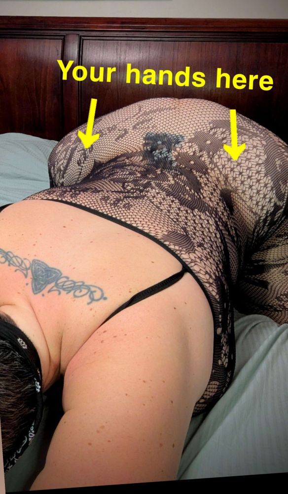 Polly bends forward on all fours with her head just off camera down into the left. Her arms are forward and her upper back tattoo is very prominent. She wears a black bandana around her head, and a floral lace bodysuit and her ass is popped in the air with her knees spread wide. She has got a rather a large caboose and her lace covered tits are smushed into the blue sheet. In yellow lettering above her ass it reads your hands here with an arrow pointing to each hip. Another picture with Polly's signature subtlety.