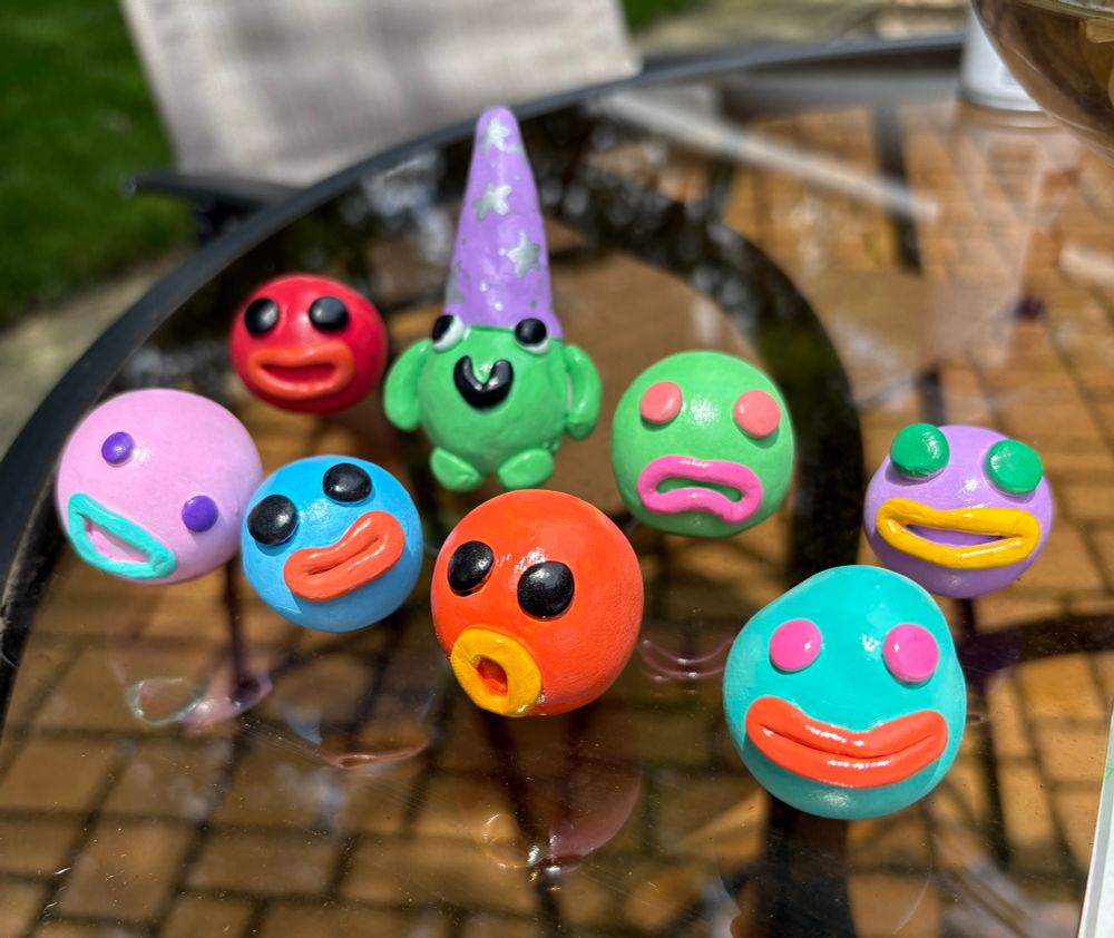 A series of wacky lil guys I made of out clay. They’re round with faces. One of them is a frog wizard with a hat