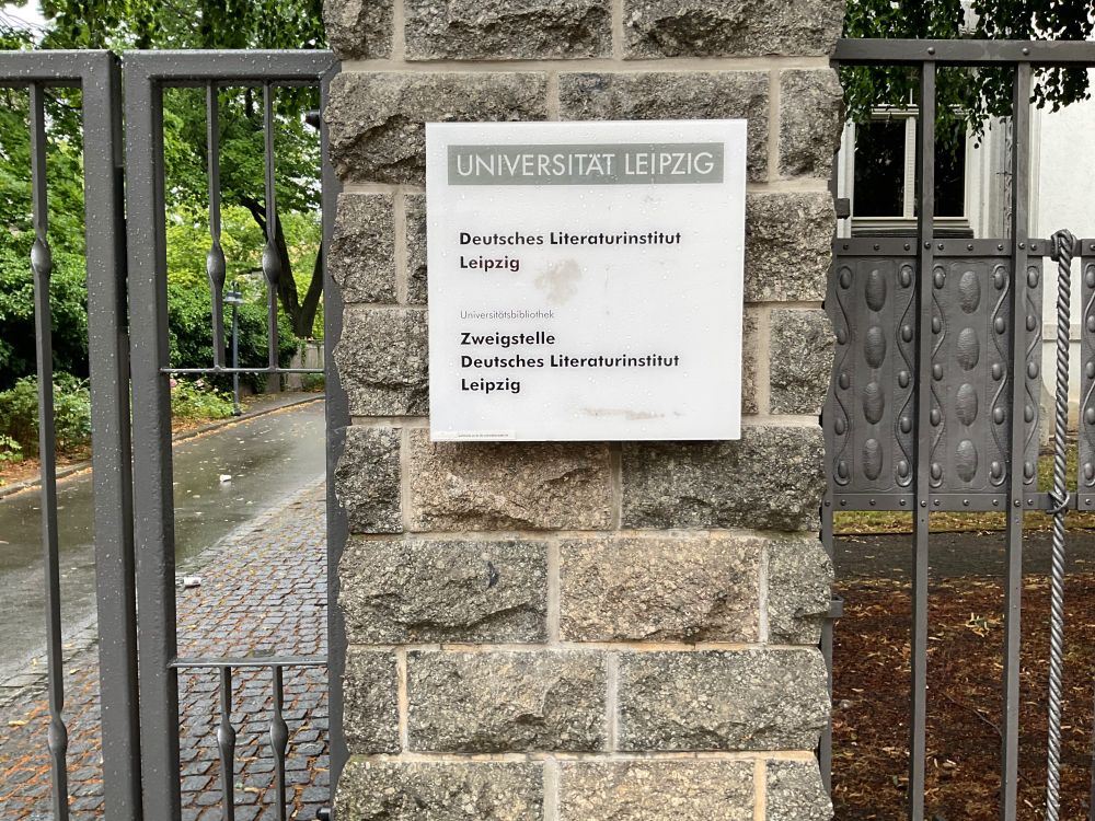 Gebäudeschild in Leipzig mit Inschrift "Universität Leipzig, Deutsches Literaturinstitut Leipzig, Universitatsbibliothek, Zweigstelle Literaturinstitut Leipzig".