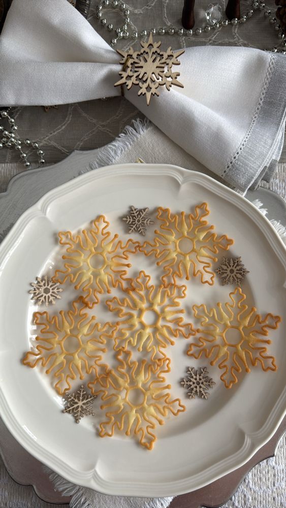 6 Snowflake tuiles on a cream plate.