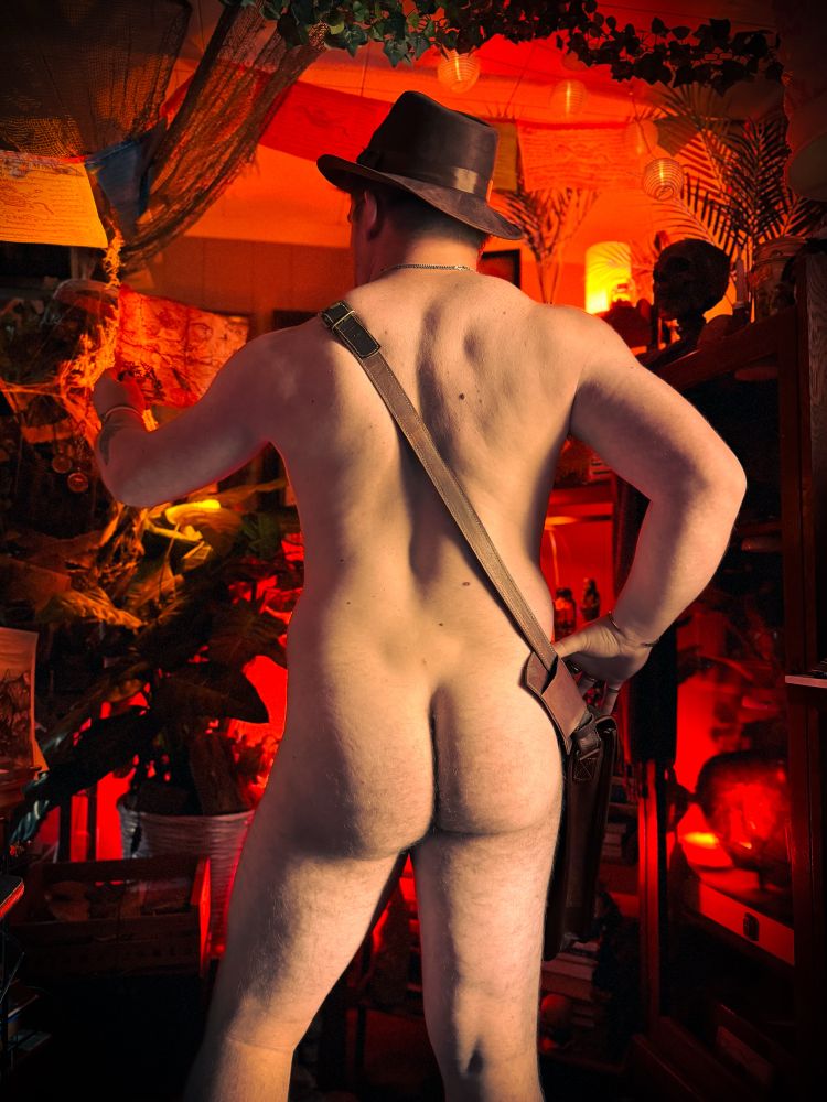 Me from behind wearing an Indiana Jones hat and satchel looking at a map 