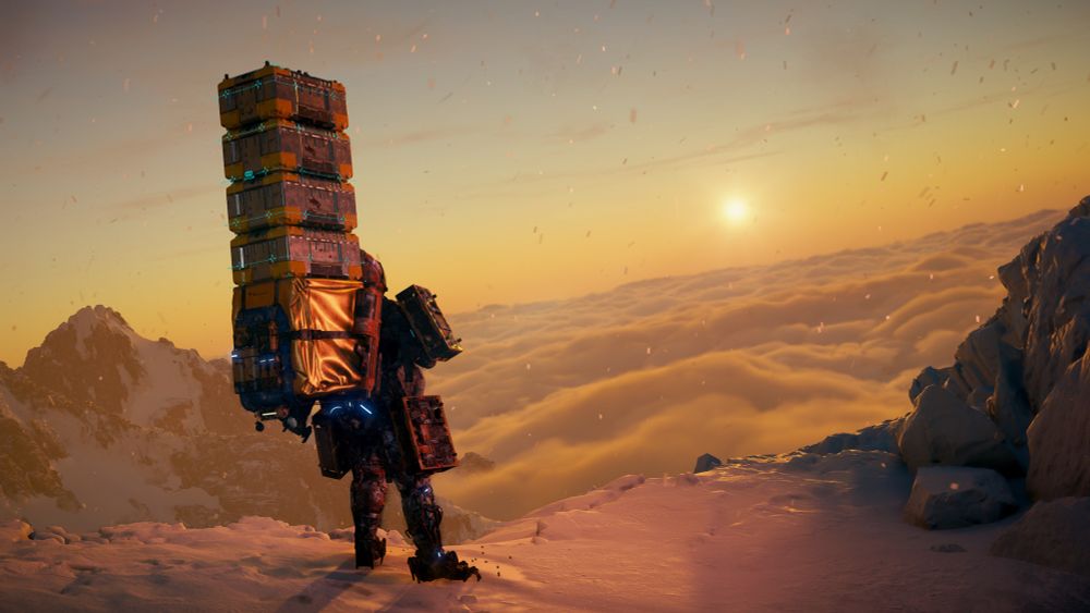Sam looking at a sunrise on a mountaintop, clouds below him