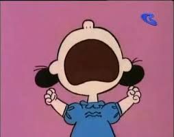 Lucy from Peanuts, in a blue dress, screaming and throwing a tantrum about something.