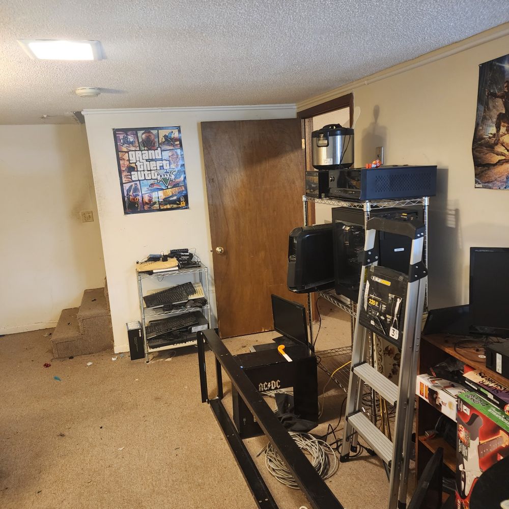 A picture of the rest of the room, looking at the stairs. There is barely-noticable white conduit running near the top of the wall. Additionally,  a previous post showed this same location with a mess of cat5e and coax cable. Now those two cables have been wrapped into two near bundles and one is stacked on top of the other. There are significantly less tripping hazard now.