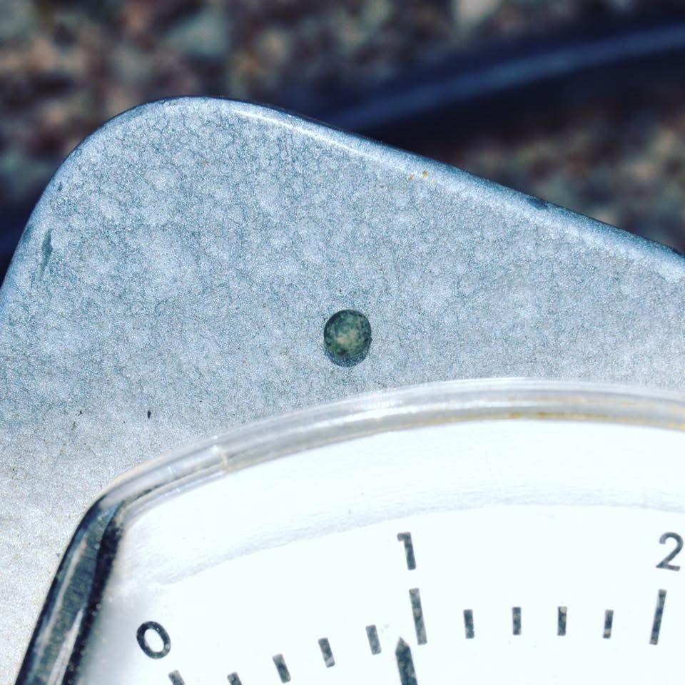 A trinitite bead sitting on a Geiger counter, trinitite being soil melt from ground zero at the first nuclear detonation.