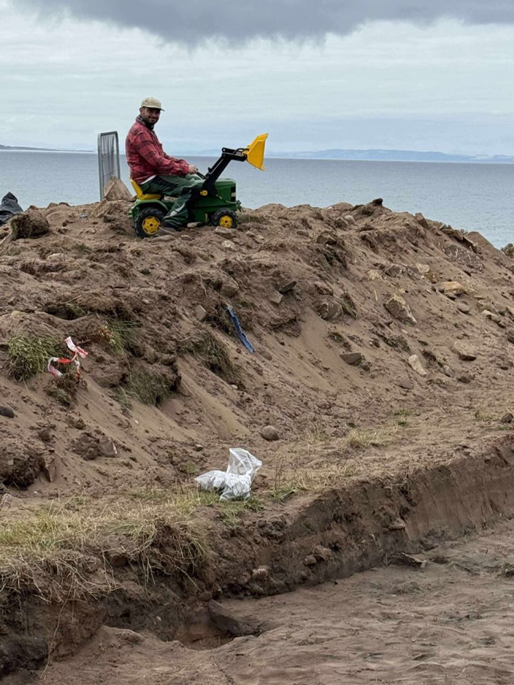 An archaeologist busy pretending to excavate with a child’s toy ride on tractor