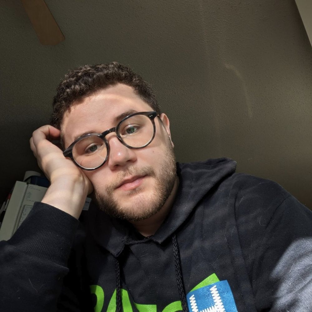 A selfie of Caleb resting his head on his hand and looking out a window. 