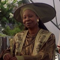 Guinan from Star Trek The Next Generation, a dark skinned Black woman with a large, circular hat.