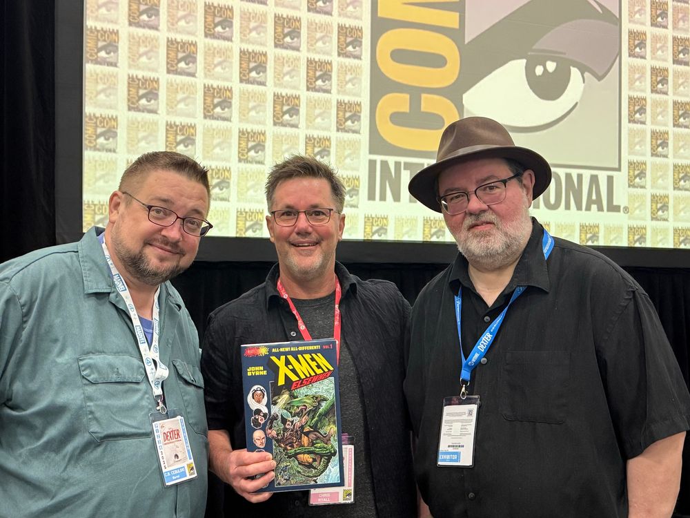 Marvel’s CB Cebulski and Tom Brevoort flank Chris Ryall, who holds up a mockup of the just announced X-Men Elsewhen volume 1 at the Abrams ComicArts/Marvel panel at the San Diego Comic-Con. 